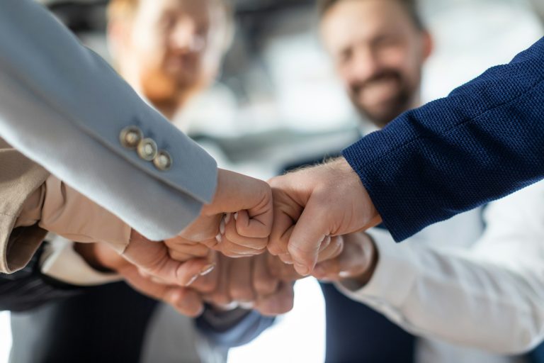 Business Team Fist Bumping in Office Setting, Cropped